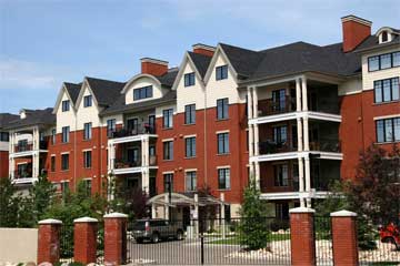 Red-brick multifamily apartment building with a pitched roof
